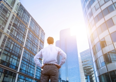 Business Man Looking Up at Buildings